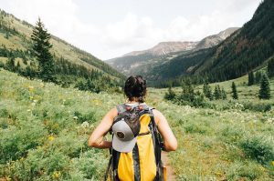 girl hiking with yellow backpack